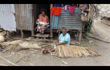 Villager weaving coconut roof cover